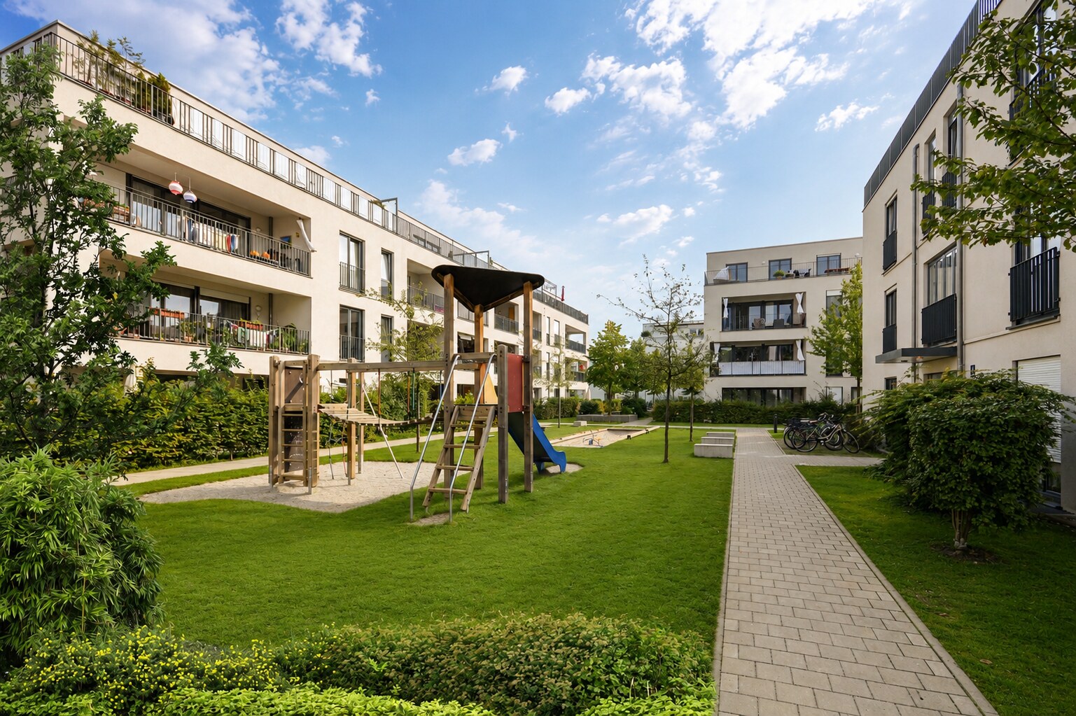 Moderne Wohnanlage mit begrüntem Innenhof, Spielplatz und gepflegten Wegen