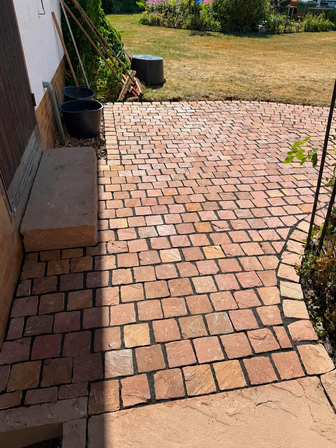 Neu gepflasterte Außenfläche mit Gartenzugang